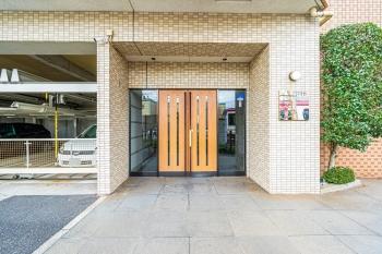 木製の両開きドアに縦型ガラスパネルがあり、上品で落ち着いた印象