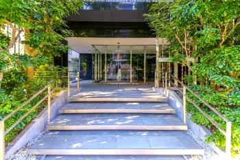 ガラス扉と豊かな植栽が調和する、洗練されたエントランス