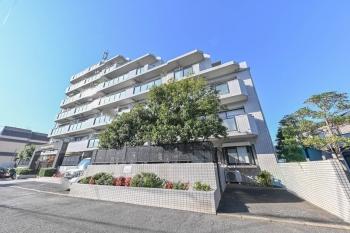 スタイリッシュなホワイト系タイル貼りの建物外観（北東側）