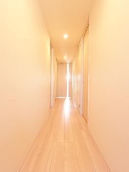 優しい色合いが広さを感じさせる、明るく伸びやかな廊下空間
