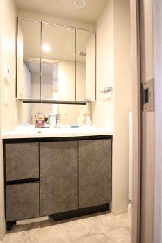 重厚感のある石目調の扉を採用した三面鏡付き洗面化粧台