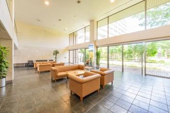 ２層吹き抜けでガラス張りの敷地内中庭を望むロビー