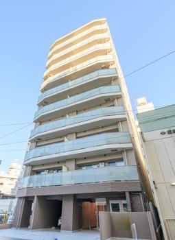 1F部分はアースカラーで全体はホワイト系タイル貼りのスタイリッシュな現地外観
