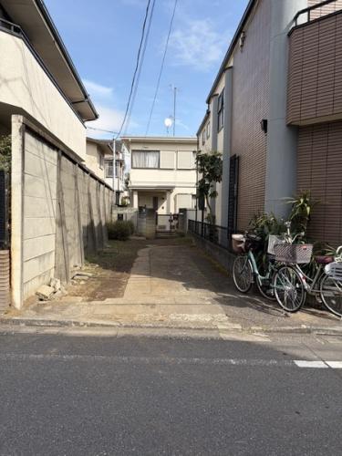 前面道路、左奥が物件となっております。