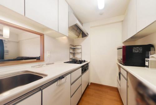 白を基調にしたシステムキッチン。背面の造付収納も大変便利です。