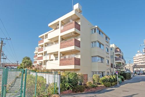 白とブラウンの外観！植栽の緑と歩道のレンガとのハーモニー