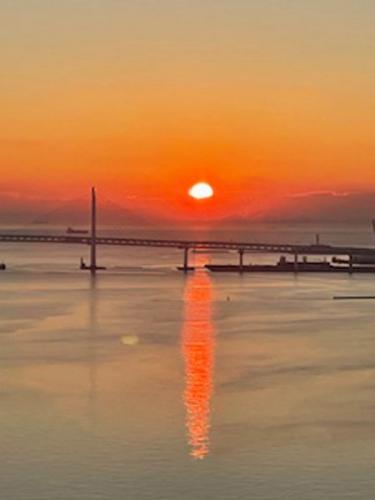 バルコニーよりベイブリッジ越しに朝日を望む