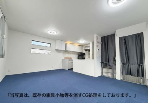 白に鮮やかなブルーのカーペットが映える16.5帖のリビング